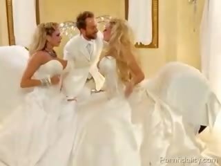 Dois blondies com enorme baloons em bridal dresses compartilhando um peter