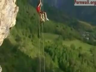 Акробатично двойка майната над на cliff капка
